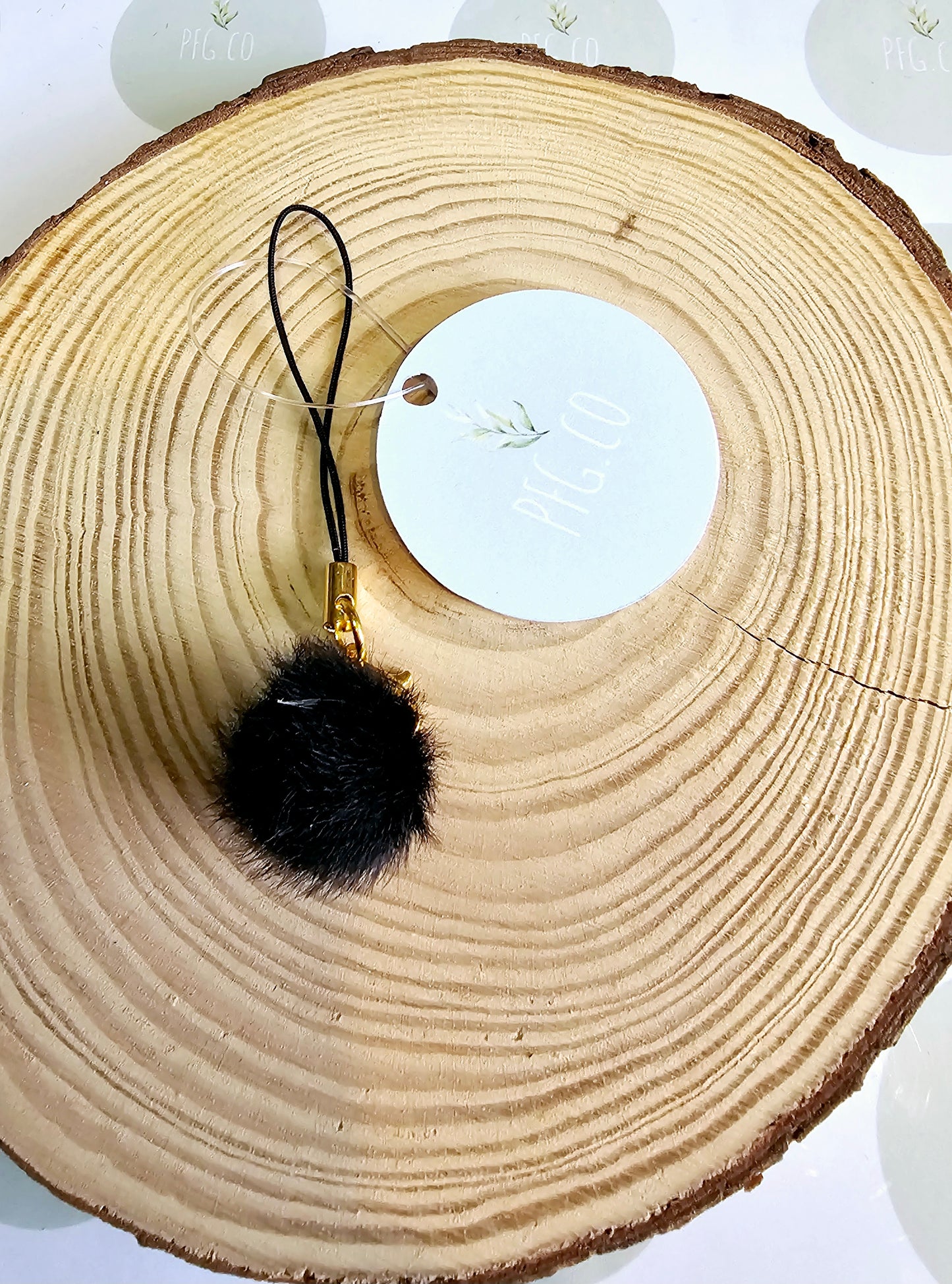 Black pompom phone charm