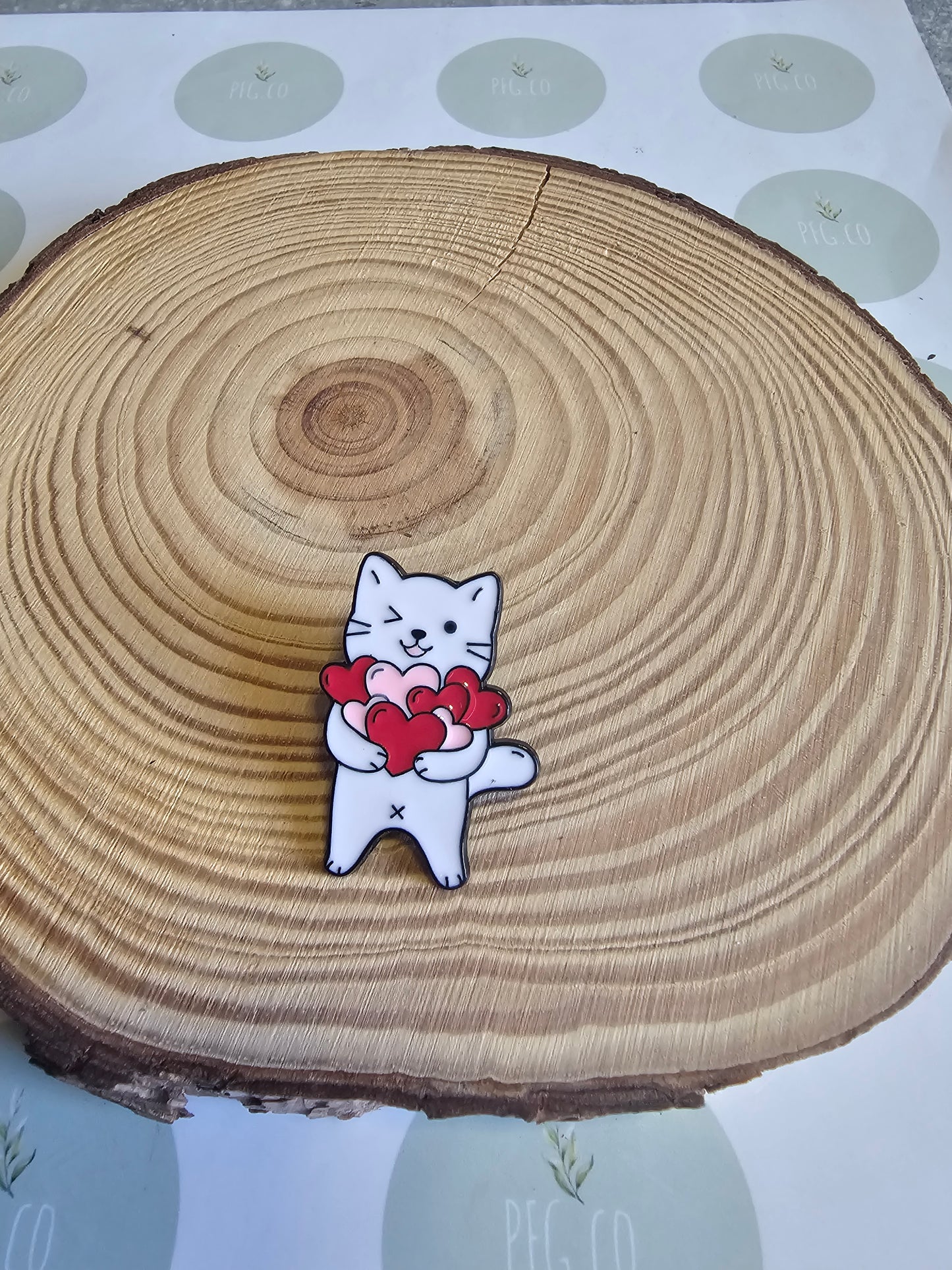 White cat with heart pin badge